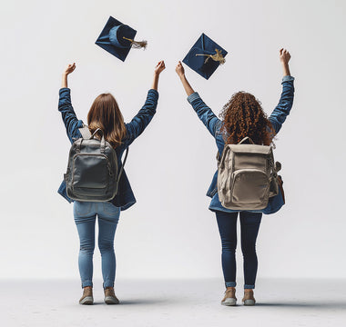 Two friends, graduation caps in the air, celebrate their achievements. 