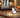 Compact indoor camera placed on a table in a bedroom, providing home security