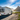 White RV parked by scenic mountains and tranquil lakeside, ideal for road trips, outdoor travel, and adventure vacations.