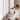 Attentive dog standing on hind legs and gazing thoughtfully out a window, illustrating pet anticipation and companionship at home.